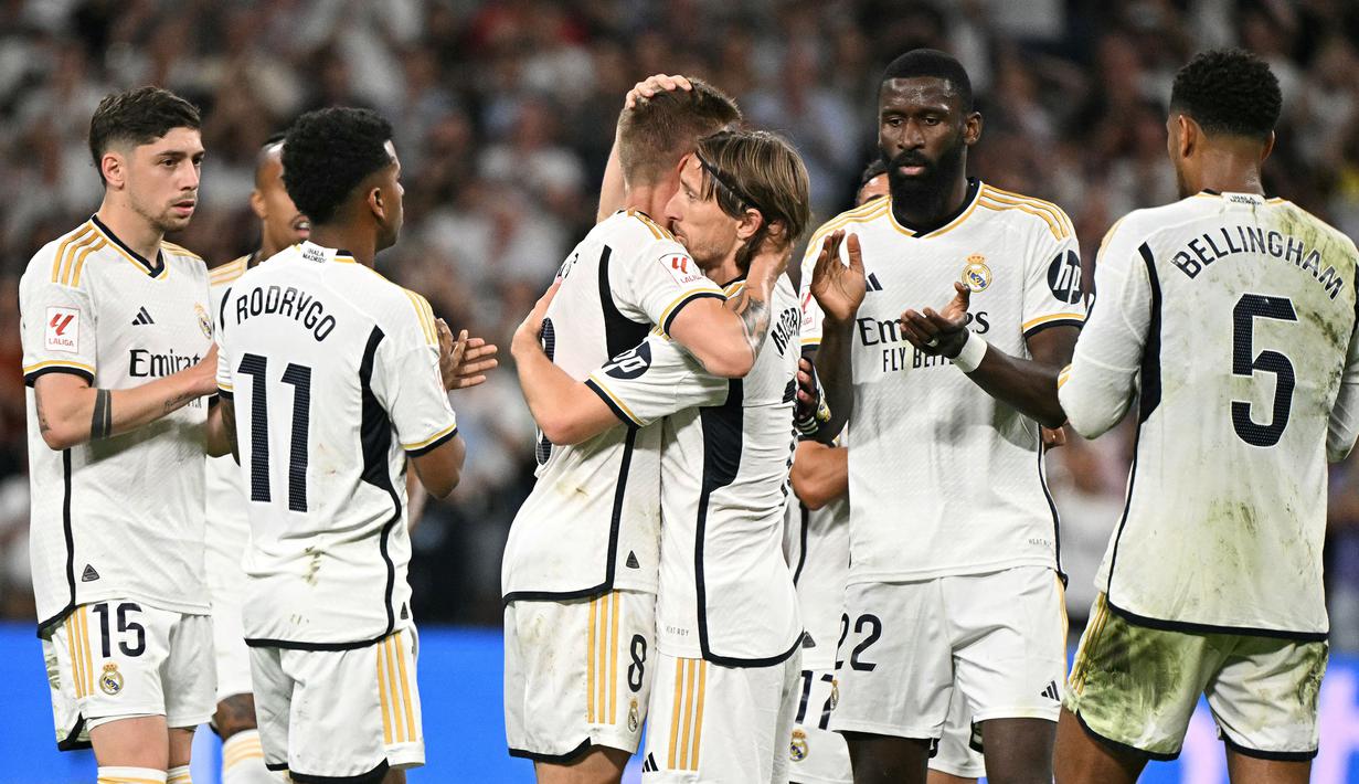 Pemain Real Madrid, Toni Kroos (tengah kiri) memeluk rekannya, Luka Modric saat upacara perpisahan setelah laga Liga Spanyol 2023/2024 melawan Real Betis di Santiago Bernabeu, Madrid, Spanyol, Minggu (26/05/2024) dini hari WIB. Kroos memutuskan untuk pensiun dari sepak bola setelah Euro 2024 nanti. (AFP/Javier Soriano)