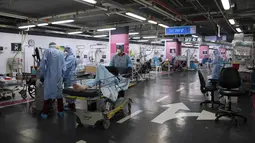 Petugas medis dengan alat pelindung diri merawat pasien COVID-19 di bangsal perawatan yang telah diubah dari tempat parkir bawah tanah, di Rumah Sakit Rambam di kota Haifa, Selasa (15/12/2020). Langkah itu sebagai tanggapan dalam menghadapi lonjakan kasus COVID-19 di Israel. (AP Photo/Oded Balilty)