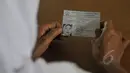Seorang peserta menunjukan kartu peserta sebelum mengikuti Ujian Nasional (UN) kesetaraan paket B di SMPN 80 Jakarta, Senin (4/5/2015). Sebanyak 378 peserta, termasuk peserta berusia lanjut mengikuti UN di hari pertama tersebut. (Liputan6.com/Johan Tallo)