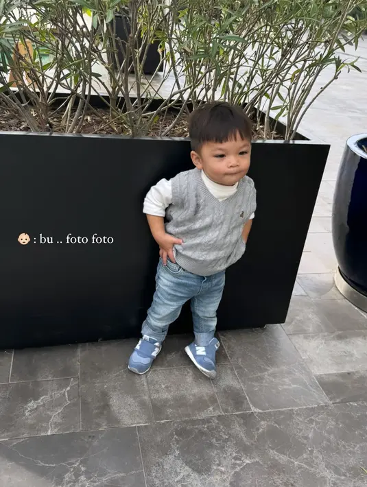 Baby Issa juga terlihat menggemaskan dengan OOTD lainnya. Ia tampil kece dengan long sleeve putih dan light jeans. Dipadukan dengan vest rajut abu-abu dan sneakers biru. [@nikitawillyofficial94]