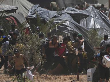 Warga Palestina berbondong-bondong mengumpulkan paket bantuan kemanusiaan dari Uni Emirat Arab yang dijatuhkan dengan parasut ke Deir al-Balah, bagian tengah Jalur Gaza, pada Selasa 19 Agustus 2025. (AP Photo/Abdel Kareem Hana)