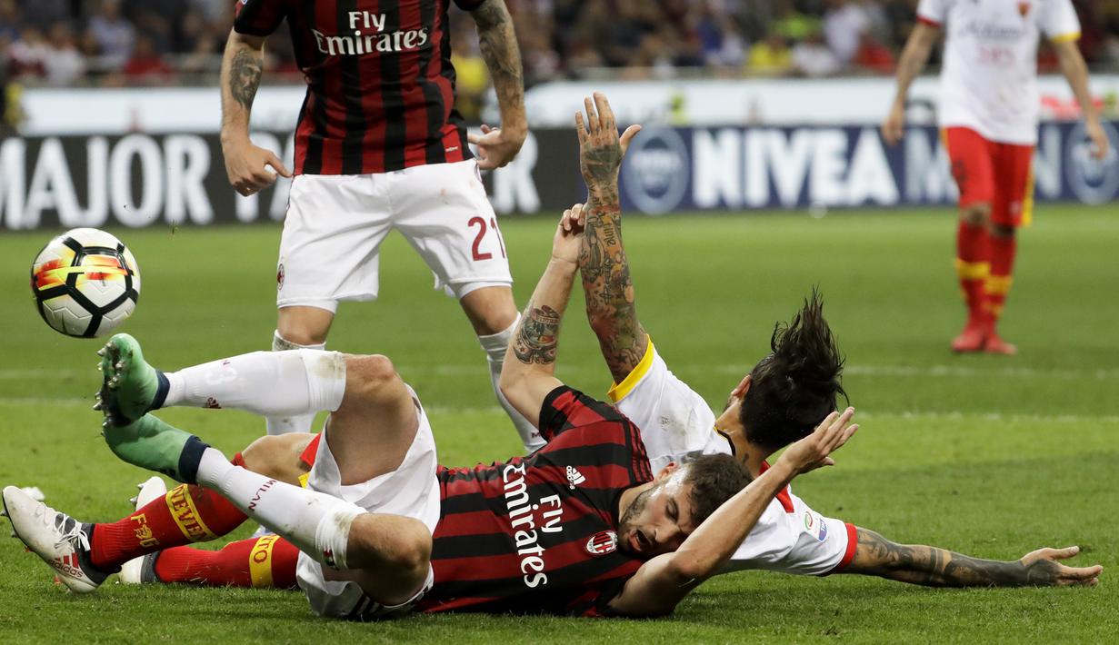 Pemain AC Milan, Patrick Cutronefront jatuh saat berebut bola dengan pemain Benevento, Nicolas Benito Viola pada laga Serie A di San Siro stadium, Milan, (21/4/2018). AC Milan kalah 0-1. (AP/Luca Bruno)