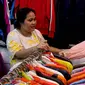 Calon pembeli menjajal pakaian impor bekas di Pasar Senen, Jakarta, Kamis (9/3/2023). Larangan impor baju bekas tercantum dalam Peraturan Menteri Perdagangan (Permendag) No.18/2021 tentang Barang Dilarang Ekspor dan Barang Dilarang Impor. (Liputan6.com/Faizal Fanani)