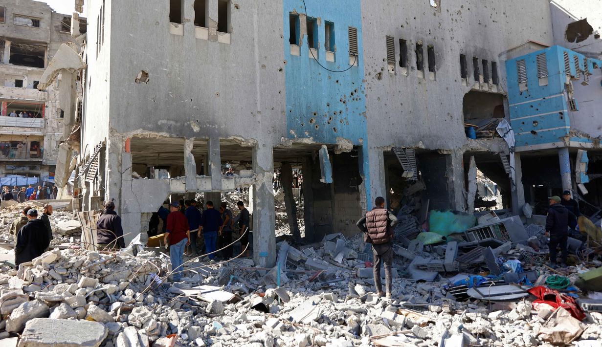 Hamas menyebut serangan Israel sebagai pelanggaran berkelanjutan yang, menurut mereka, menunjukkan pemerintah Israel terus melanjutkan genosida terhadap warga Palestina di Gaza. Tampak dalam foto, tim penyelamat dan warga yang menyaksikan kejadian tersebut memeriksa puing-puing kantor polisi Sheikh Radwan di Kota Gaza pada 31 Januari 2026. (Omar AL-QATTAA/AFP)