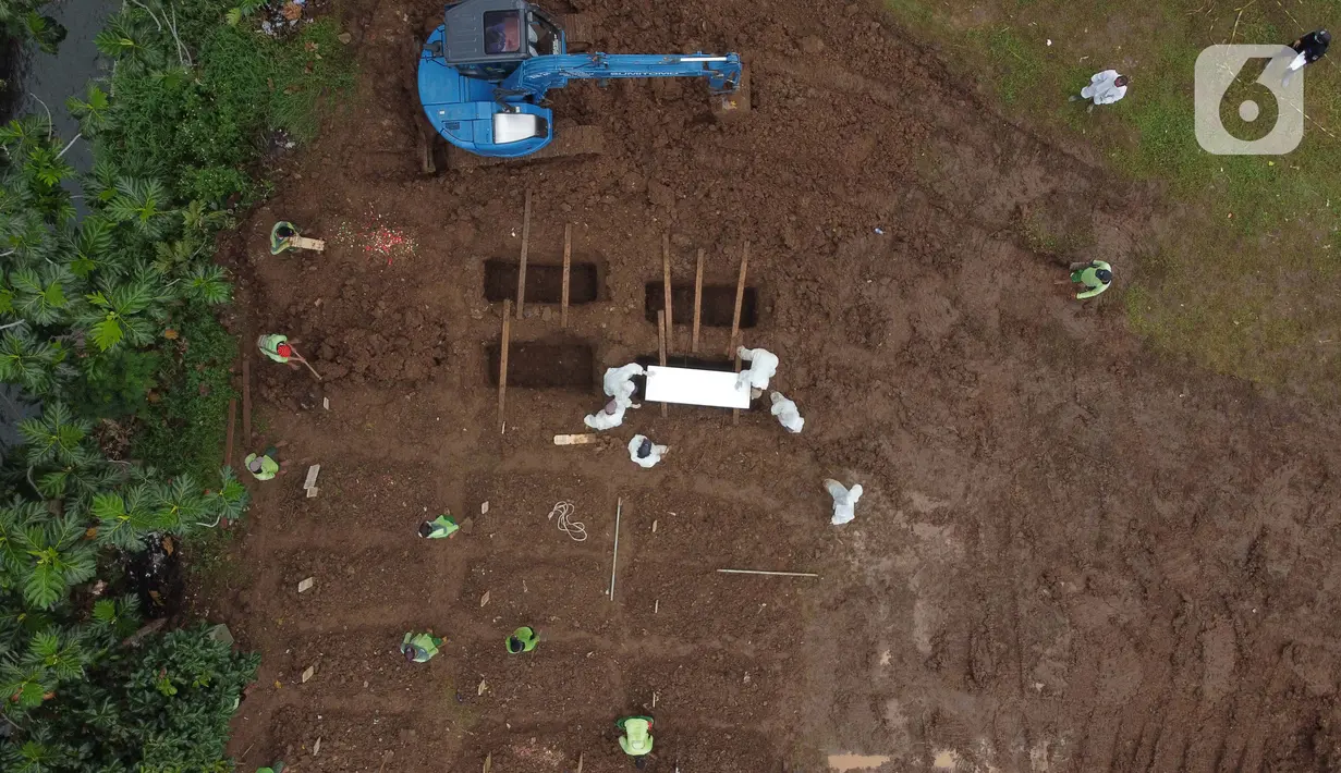 Foto udara pemakaman jenazah dengan protokol COVID-19 di TPU Srengseng Sawah, Jakarta, Kamis (21/1/2021). Sebagian lahan TPU Srengseng Sawah yang dijadikan pemakaman jenazah Covid-19 sejak Selasa (12/1) lalu, dengan kapasitas 564 petak makam kini nyaris penuh. (Liputan6.com/Helmi Fithriansyah)