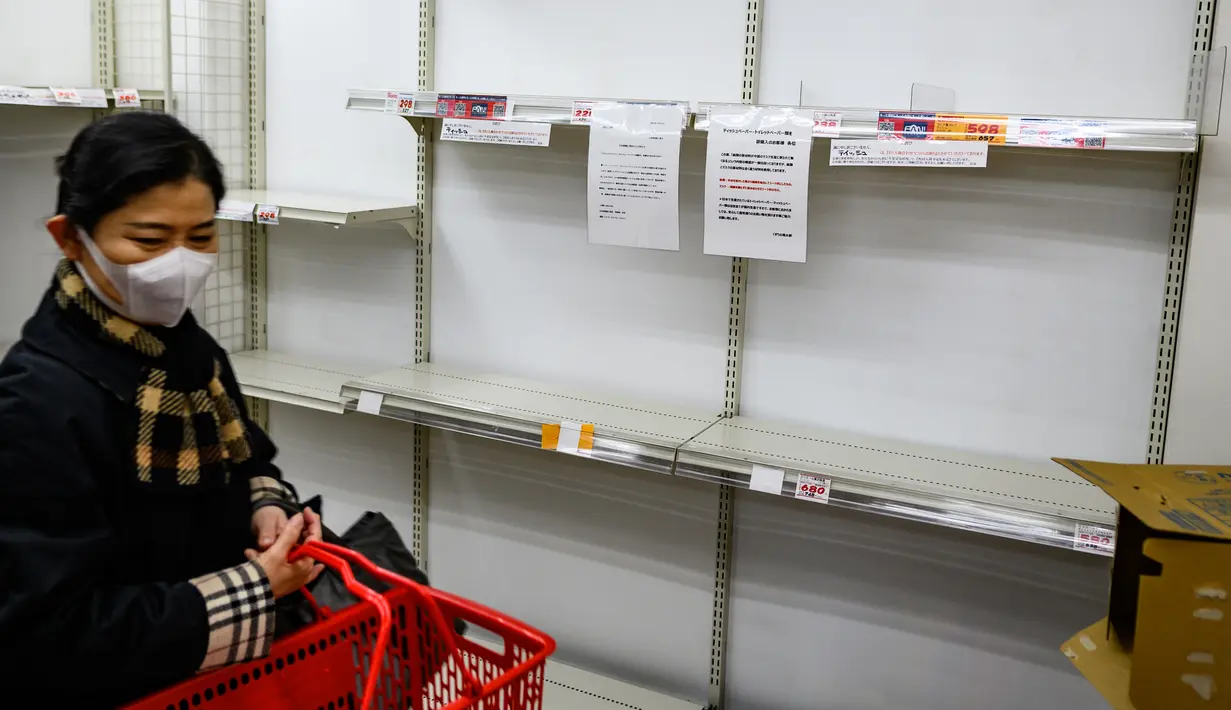 Pengunjung melewati rak-rak supermarket kosong yang biasanya penuh dengan tisu toilet di Tokyo, Minggu (1/3/2020). Warga Jepang yang sedang waspada wabah virus corona tipe baru, Covid-19 dilanda kepanikan setelah muncul gosip bahwa China tidak akan lagi mengekspor kertas toilet. (Philip FONG/AFP)