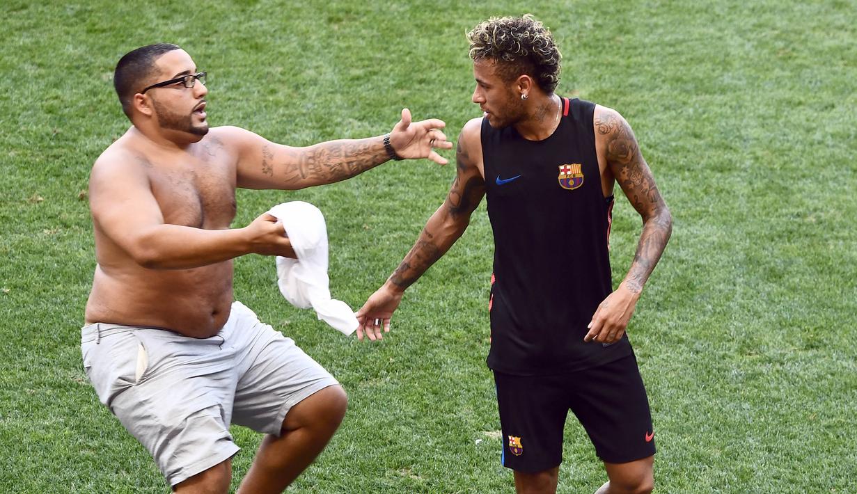 Seorang fans masuk ke lapangan mengejar pemain Barcelona, Neymar, saat latihan di Red Bull Arena, New Jersey, Jumat (21/7/2017). Latihan ini dilakukan jelang laga ICC 2017 melawan Juventus. (AFP/Jewel Samad)