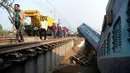 Sejumlah orang melihat kondisi kereta api yang tergelincir di Kanpur, India utara, Rabu (28/12). Peristiwa tersebut mengakibatkan 2 orang tewas dan 43 lainnya luka-luka. (AFP PHOTO / SANJAY Kanojia)