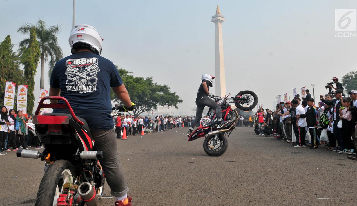 Freestyler melakukan atraksi freestyle sepeda motor saat memeriahkan Festival Damai Millenial Road Safety di Monas, Jakarta, Minggu (23/6/2019). Festival ini menyosialisasikan disiplin berlalu lintas serta merajut persatuan dan kesatuan, khususnya generasi millienial. (merdeka.com/Iqbal Nugroho)