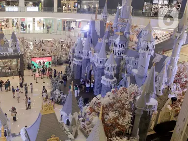 Pengunjung berfoto dengan latar belakang ornamen Natal yang terpajang di Mal Senayan City, Jakarta, Kamis (14/12/2023). (Liputan6.com/Herman Zakharia)