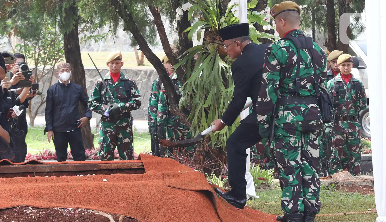 Menteri Koordinator Bidang Pembangunan Manusia dan Kebudayaan, Muhadjir Effendy, menimbun liang lahat dengan tanah secara simbolis saat prosesi pemakaman Azyumardi Azra di Taman Makam Pahlawan Kalibata, Jakarta, Selasa (20/9/2022). Sejumlah pelayat hadir memberikan penghormatan terakhir kepada almarhum. (Liputan6.com/Herman Zakharia)