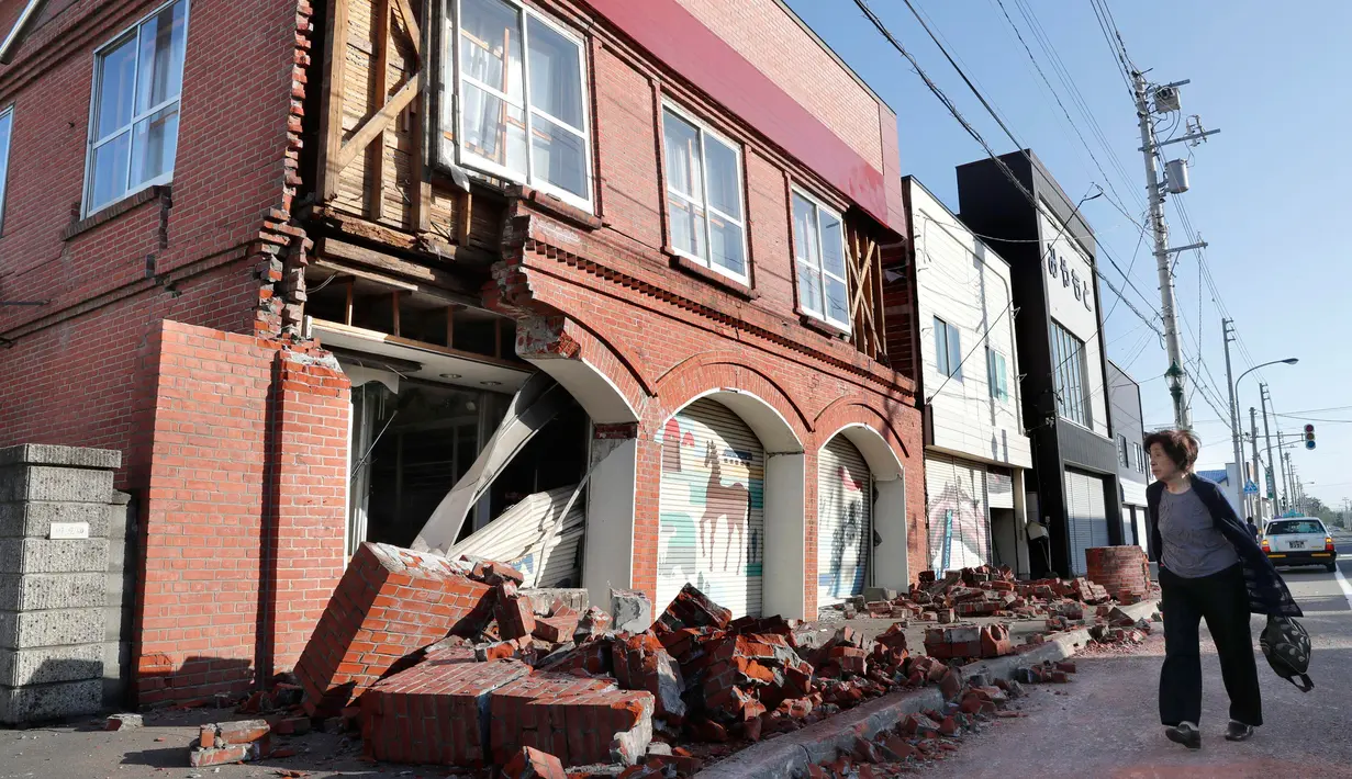 Seorang warga melihat kondisi bangunan yang rusak akibat gempa mengguncang Kota Abira di Hokkaido, Jepang, Kamis (6/9). Bencana ini telah menewaskan sedikitnya dua orang dan puluhan lainnya masih dalam proses pencarian. (Masanori Takei/Kyodo News via AP)
