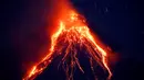 Pemandangan ketika lava panas keluar dari puncak Gunung Mayon yang berada di Kota Legazpi, Provinsi Albay, Filipina, Selasa (23/1). Gunung berapi paling aktif di Filipina ini mengeluarkan lava, abu, dan asap. (AP Photo/Bullit Marquez)