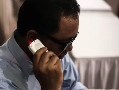 Seorang penyandang tuna netra mencoba alat saat peluncuruan Audiobook Library for the Blind di Kemenko PMK, Jakarta, Selasa (17/5). Aplikasi tersebut membantu para penyandang tunanetra untuk membaca melalui media aplikasi. (Liputan6.com/Faizal Fanani)