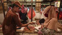 Pedagang daging melayani pembeli di Pasar Kebayoran Lama, Jakarta, Senin (3/5/2021). Pemerintah melalui Menteri Pertanian Syahrul Yasin Limpo menegaskan pihaknya siap melakukan intervensi jika stok daging langka dan terdapat lonjakan harga pada bulan Ramadan. (Liputan6.com/Johan Tallo)