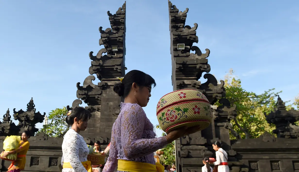 Sejumlah wanita Hindu membawa sesajen menuju pura untuk sembahyang Hari Raya Galungan di Jimbaran, Bali, Rabu (5/4). Galungan dirayakan oleh umat hindu di Bali sebagai hari kemenangan Dharma (Kebaikan) melawan Adharma (Keburukan). (SONNY TUMBELAKA/AFP)
