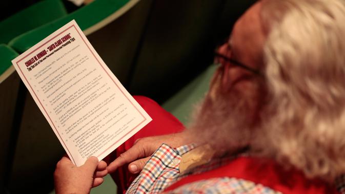 Seorang siswa sekolah Santa Claus Charles W. Howard mendapat pelajaran bagaimana menjadi Santa yang sukses di Midland, Michigan, Jumat (19/10). Sekolah ini khusus mengajarkan para lansia yang ingin menjadi sinterklas. (JEFF KOWALSKY / AFP)