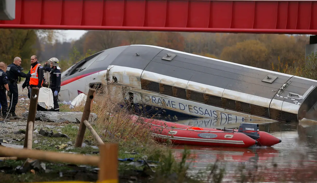 Petugas saat melakukan evakuasi terhadapa kereta yang tergelincir dan jatuh disebuah sungai dekat Strasbourg, Perancis, Sabtu (14/11/2015). Diduga kereta tergelincir karena menggunakan kecepatan yang berlebihan. (REUTERS/Vincent Kessler)