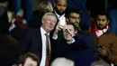 Mantan manajer Manchester United Sir Alex Ferguson berselfie dengan fans saat menyaksikan pertandingan antara Manchester United dengan Chelsea di Stadion Old Trafford, Inggris (28/12). MU bermain imbang dengan Chelsea dengan skor 0-0. (Reuters/Phil Noble)