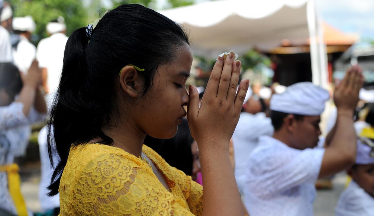 Umat Hindu berdoa saat perayaan Kuningan di sebuah pura di Pulau Serangan, Denpasar, Bali, Sabtu (20/2). Kuningan merupakan hari terakhir perayaan Galungan diyakini menjadi hari kekuasaan roh suci leluhur kembali ke langit. (AFP PHOTO/SONNY Tumbelaka)