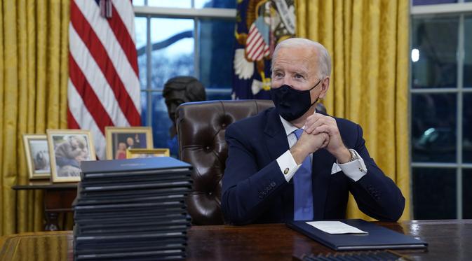 Presiden Joe Biden saat berada pertamanya di Ruang Oval, Gedung Putih di Washington, Rabu (20/1/2021). Pada hari pertamanya menjabat, Presiden Amerika Serikat Joe Biden menandatangani sejumlah tindakan eksekutif di Gedung Putih. (AP Photo/Evan Vucci)