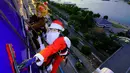 Dua petugas pembersih kaca jendela berkostum Santa Claus dan rusa membersihkan kaca-kaca gedung bertingkat di pusat perbelanjaan di Tokyo, Kamis (21/12). Para pekerja ini melakukannya untuk merayakan Natal 25 Desember. (AP/Shizuo Kambayashi)