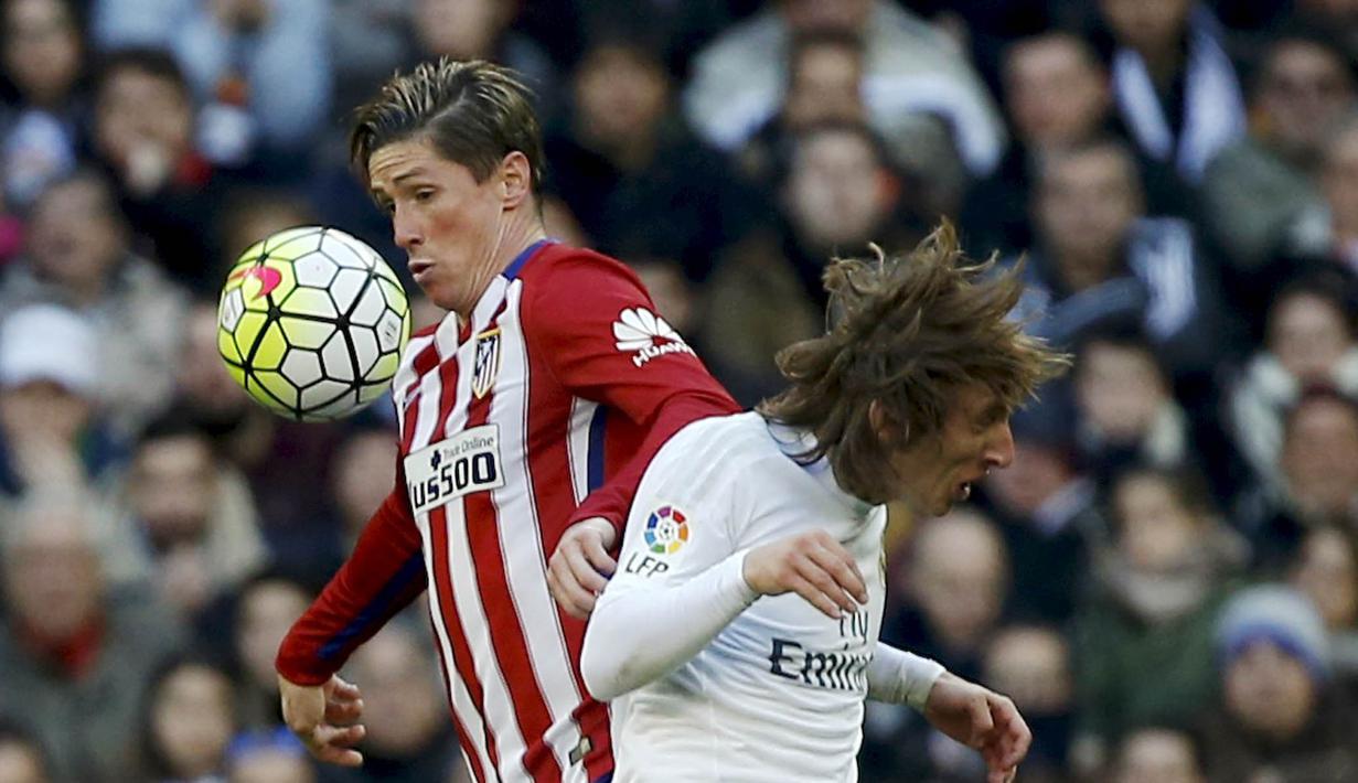 Pemain Atletico Madrid, Fernando Torres mengotrol bola saat berduel dengan pemain Real Madrid, Luka Modric pada lanjutan La Liga Spanyol pekan ke-26 di Stadion Santiago Bernabeu, Sabtu (27/2/2016) Malam WIB. (REUTERS/Sergio Perez)