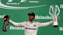 Lewis Hamilton dengan trofi juara F1 GP Kanada di Sirkuit Gilles Villeneuve, Kanada, Senin (13/6/2016) dini hari WIB. (AFP/Getty Images/Mark Thompson)