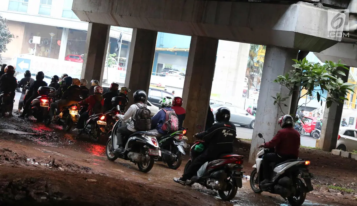 Pengendara motor melintasi jalan setapak di kolong tol di kawasan Lebak Bulus, Jakarta, Selasa (13/2). Untuk menghindari macet sebagian pengendara memanfaatkan jalan setapak tersebut untuk memersingkat waktu tempuh. (Liputan6.com/Immanuel Antonius)