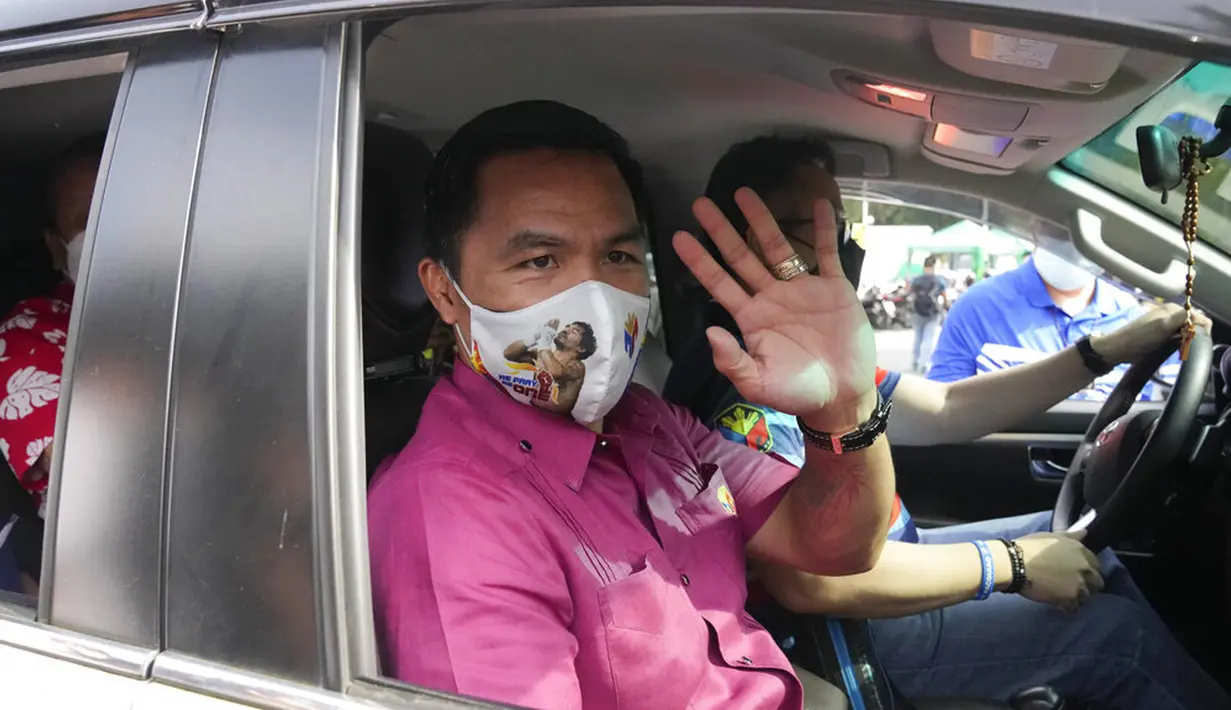 Pensiunan bintang tinju dan senator Filipina Manny Pacquiao melambai dari kendaraannya sebelum mengajukan sertifikat pencalonannya untuk pemilihan presiden tahun depan di Komisi Pemilihan Umum, Manila, Filipina, Jumat (1/10/2021). (AP Photo/Aaron Favila)