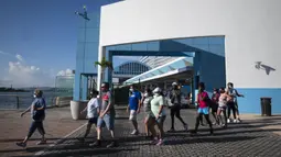 Penumpang keluar dari kapal pesiar Mardi Gras Carnival yang berlabuh di Teluk San Juan, Puerto Rico, Selasa (3/8/2021). Mardi Gras Carnival menjadi kapal pesiar pertama yang mengunjungi wilayah AS sejak pandemi COVID-19. (AP Photo/Carlos Giusti)