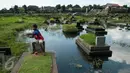 Seorang bocah bermain layang-layang diatas makam di Tempat Pemakaman Umum (TPU) Tanah Kusir, Jakarta, Selasa (25/4). (Liputan6.com/Gempur M. Surya)