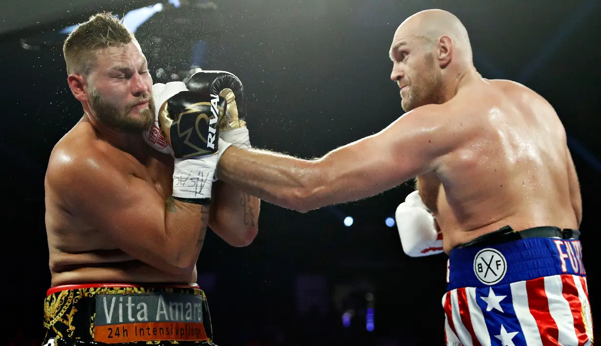 Petinju Inggris Tyson Fury melancarkan pukulan ke arah wajah petinju petinju Jerman Tom Schwarz saat bertarung pada tinju kelas berat di MGM Grand Arena, Las Vegas, AS (16/6/2019). (AP Photo/John Locher)