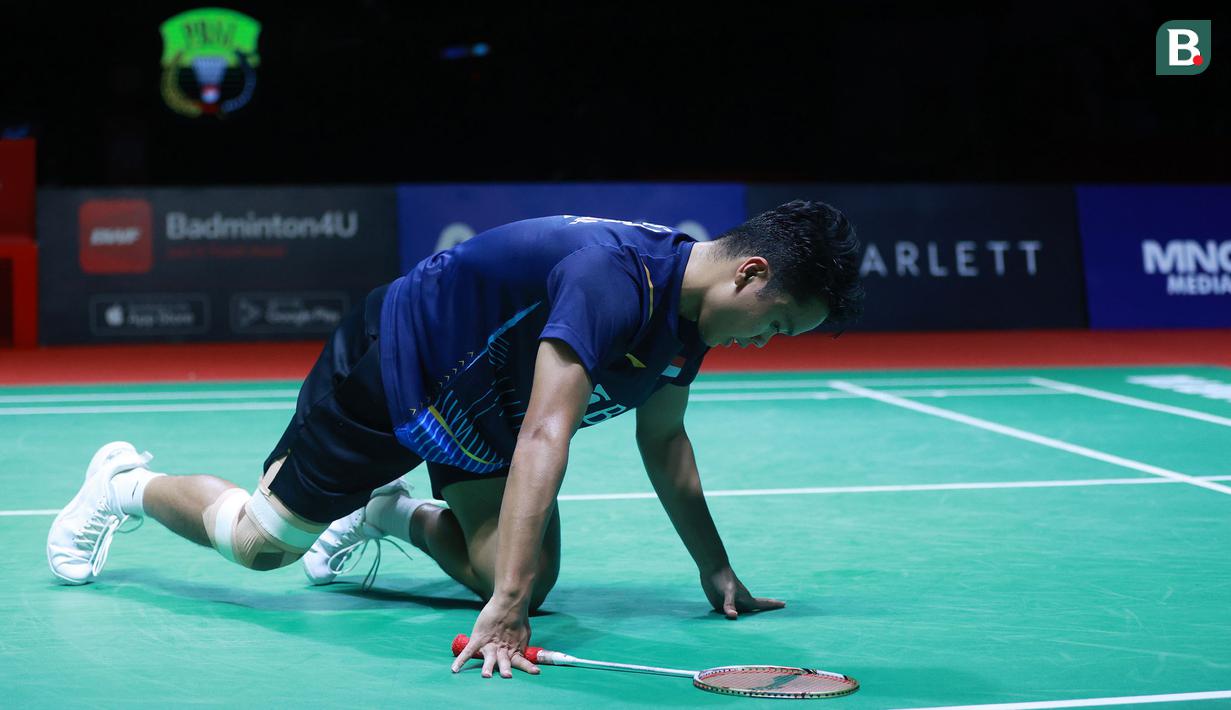 Tunggal putra Indonesia, Anthony Ginting, terjatuh saat melawan wakil Denmark, Viktor Axelsen, pada laga final Indonesia Open 2023 di Istora Gelora Bung Karno, Jakarta, Minggu (18/6/2023) Axelsen menang dengan skor 21-14 dan 21-13. (Bola.com/M Iqbal Ichsan)