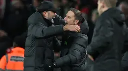 Ekspresi bahagia pelatih Liverpool, Jurgen Klopp (kiri), dengan memeluk asisten pelatih, Pepijn Lijnders (tengah), setelah Liverpool memenangkan pertandingan putaran ketiga FA Cup 2023/2024 melawan Arsenal yang berlangsung di Emirates Stadium, Minggu (7/1/2024) malam WIB. (AFP/Ben Stansall)