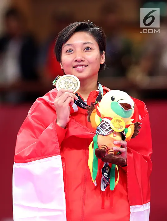 Karateka putri Indonesia, Cokorda Istri Agung Sanistyarani menunjukkan medali perunggu usai memenangkan pertandingan melawan karateka China, Jiamie Ding di babak final nomor Kumite 55 kg di JCC Senayan, Jakarta, Minggu (26/8). (Liputan6.com/Fery Pradolo)