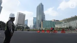 Petugas kepolisian berjaga di kawasan Bundaran HI, Jakarta, Minggu (20/10/2019). Car free day (CFD) ditiadakan Minggu (20/10) ini dalam rangka pelantikan Presiden dan Wapres periode 2019-2024, Joko Widodo dan Ma'aruf Amin di Kompleks Parlemen, Senayan, Jakarta. (Liputan6.com/Herman Zakharia)