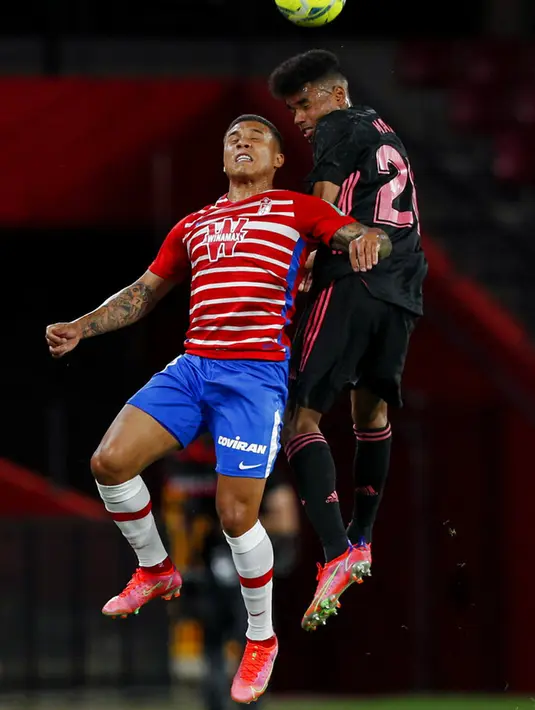 Pemain Granada Darwin Machis (kiri) berebut bola udara dengan pemain Real Madrid Marvin Olawale Akinlabi Park pada pertandingan La Liga di Stadion Los Carmenes, Granada, Spanyol, Kamis (13/5/2021). Real Madrid menang telak 4-1 atas Granada. (AP Photo/Fermin Rodriguez)