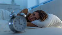 Wanita dengan insomnia berbaring di tempat tidur dengan mata terbuka. (Shutterstock/Photoroyalty)