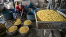 Lonjakan harga bahan baku pembuatan tahu ini berdampak langsung pada biaya produksi dan keuntungan para perajin. Tampak dalam foto, seorang pekerja menyiapkan kedelai di pabrik tahu, Surabaya, Jawa Timur pada Kamis 5 Februari 2026. (JUNI KRISWANTO/AFP)