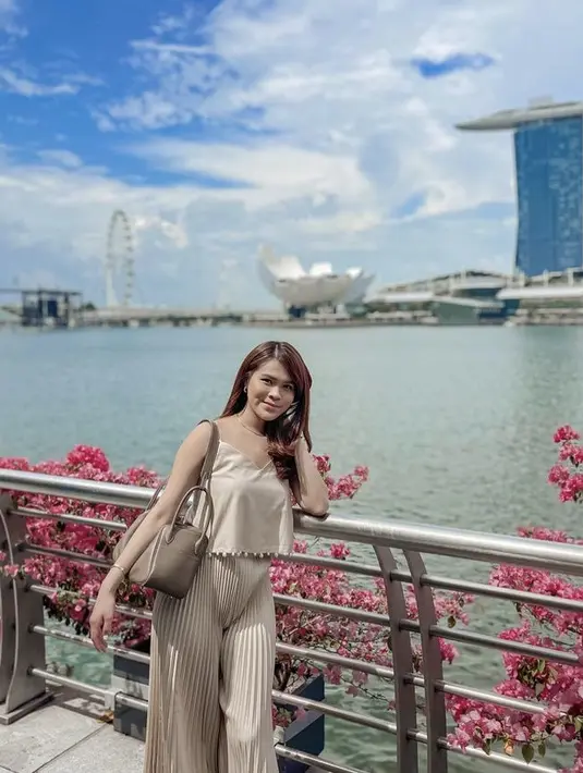 Berada di Singapura, ia tampil serba coklat mengenakan atasan spaghetti strap dipadukan celana plisket dan tas Hermesnya.  (@chengiovanis)