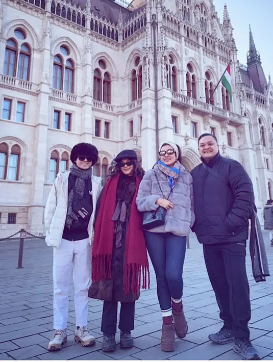 Berada di Hungary, Liza mengenakan jaket puffer abu-abu dipadukan celana ketat hitam. Putrinya mengenakan coat coklat dipadukan syal merah dan celana panjang hitamnya. [@lizanataliaofficial]