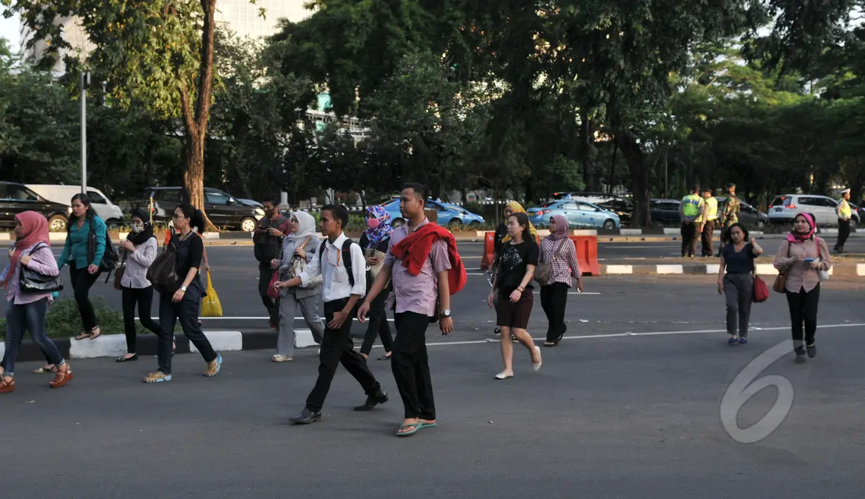 Kondisi kawasan Sudirman saat jam pulang kantor, Jakarta, Rabu, (22/4/2015). Adanya pengalihan arus untuk KAA membuat mereka terpaksa jalan kaki. (Liputan6.com/Johan Tallo)