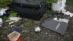 Sebuah koper terlihat tergeletak dilokasi jatuhnya pesawat MH17, Ukraina, Jumat (18/7/14). (REUTERS/Maxim Zmeyev)