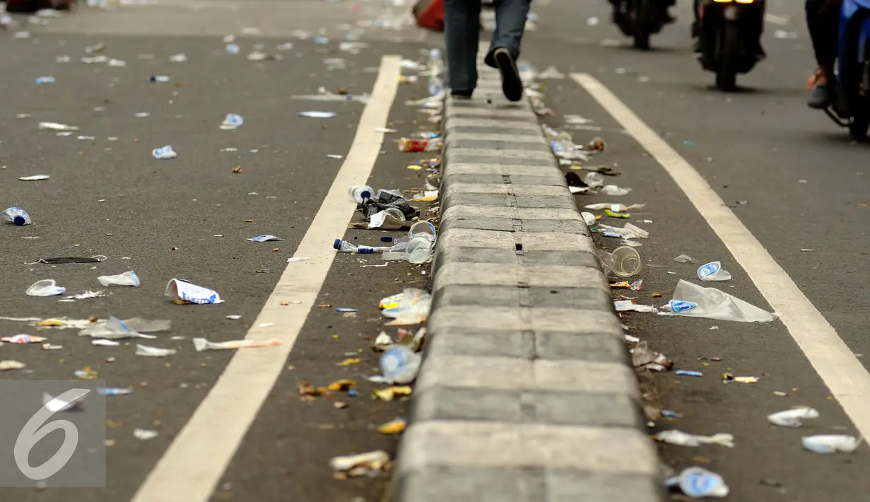 Sisa kemasan makanan dan minuman bertebaran di Jalan Medan Merdeka Timur usai ribuan massa ormas melakukan unjuk rasa di Bareskrim Polri, Gedung KKP Jakarta, Jumat (14/10). Dalam aksinya, massa meminta Ahok ditahan. (Liputan6.com/Helmi Fithriansyah)