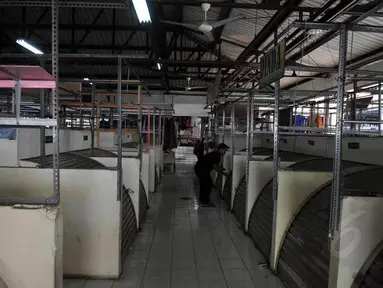 Seorang pedagang di Pasar Blok G Tanah tampak menutup kiosnya lantaran sepinya pembeli (Liputan6.com/Johan Tallo)