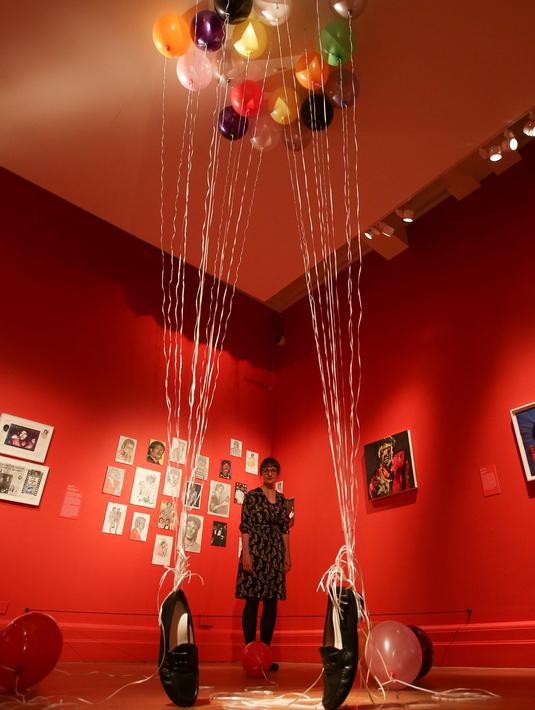 Petugas berpose dekat karya seni seniman Inggris Appau Jnr Boakye-Yiadom pada pameran 'Michael Jackson: On The Wall' di National Potrait Gallery, London, Rabu (27/6). Pameran ini berlangsung dari 28 Juni hingga 21 Oktober 2018. (Daniel LEAL-OLIVAS/AFP)