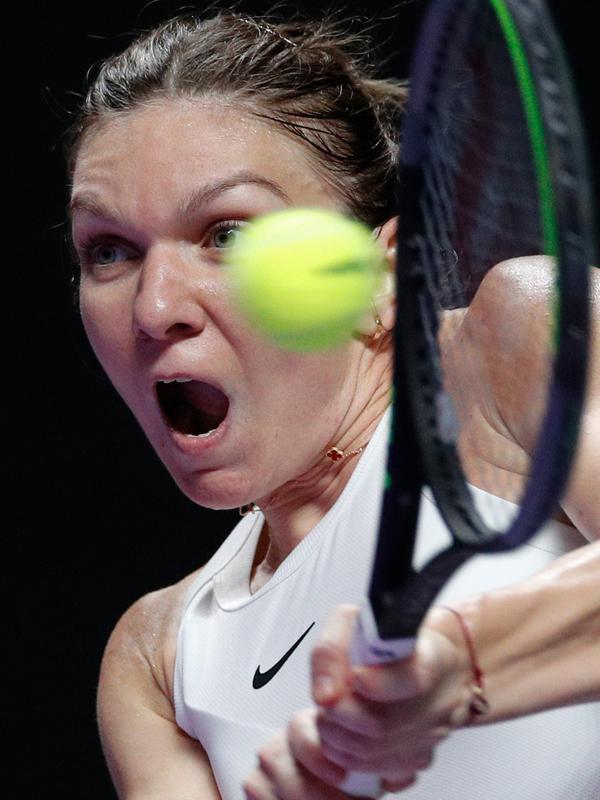 Petenis Rumania, Simona Halep berusaha mengembalikan bola ke petenis Kanada, Bianca Andreescu selama turnamen WTA Finals 2019 di Shenzhen, China, Senin (28/10/2019). Juara Wimbledon musim ini, Simona Halep merebut kemenangan 3-6, 7-6, 6-3 dalam waktu 2 jam 34 menit atas Andreescu. (AP/Andy Wong)