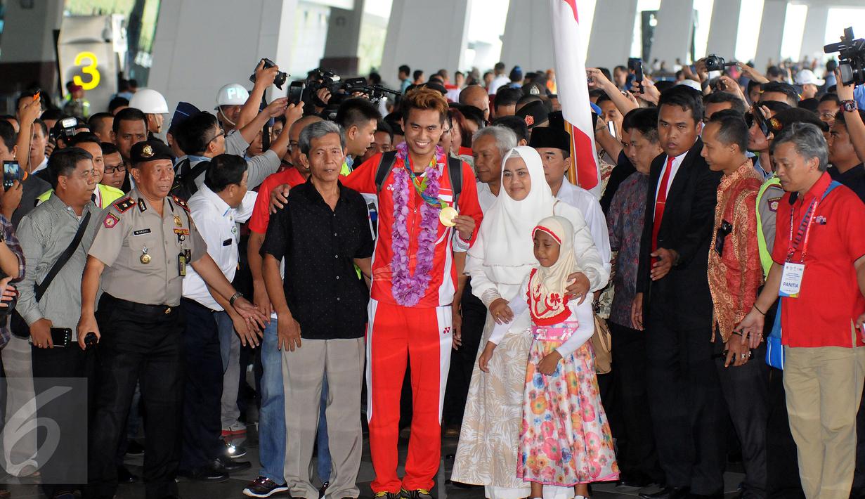 Ganda campuran Indonesia, Tontowi Ahmad bersama sang ayah memamerkan medali emas sesaa ttiba di Bandara Soekarno Hatta, Banten, Selasa (23/8/2016). Tontowi Ahmad/Lilyana Natsir berhasil meraih emas olimpiade Rio 2016. (Liputan6.com/HelmiFithriansyah)