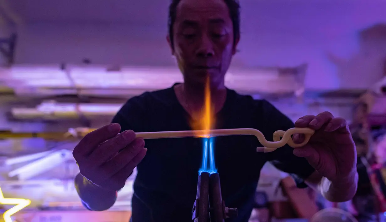 Wu Chi-kai mendemonstrasikan bagaimana membuat neon sign selama wawancara dengan AFP di Hong Kong (16/4). Wu Chi-kai merupakan salah satu pengrajin neon sign yang tersisa dari jenisnya di Hong Kong. (AFP Photo/Philip Fong)